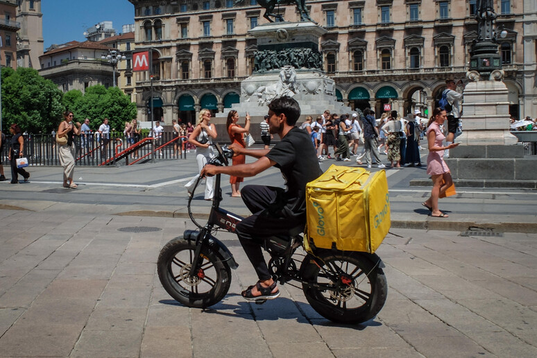 Rider alla guida di un "ciclo a propulsione" mentre fa una consegna in Piazza Duomo a Milano | Elettronauti.it