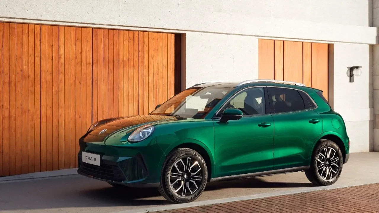 Elettronauti - GWM ORA 5 · Vista anteriore laterale di un SUV compatto verde, con tetto chiaro, cerchi bicolore e finiture nere.